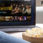a bowl of popcorn in front of a laptop flix hq